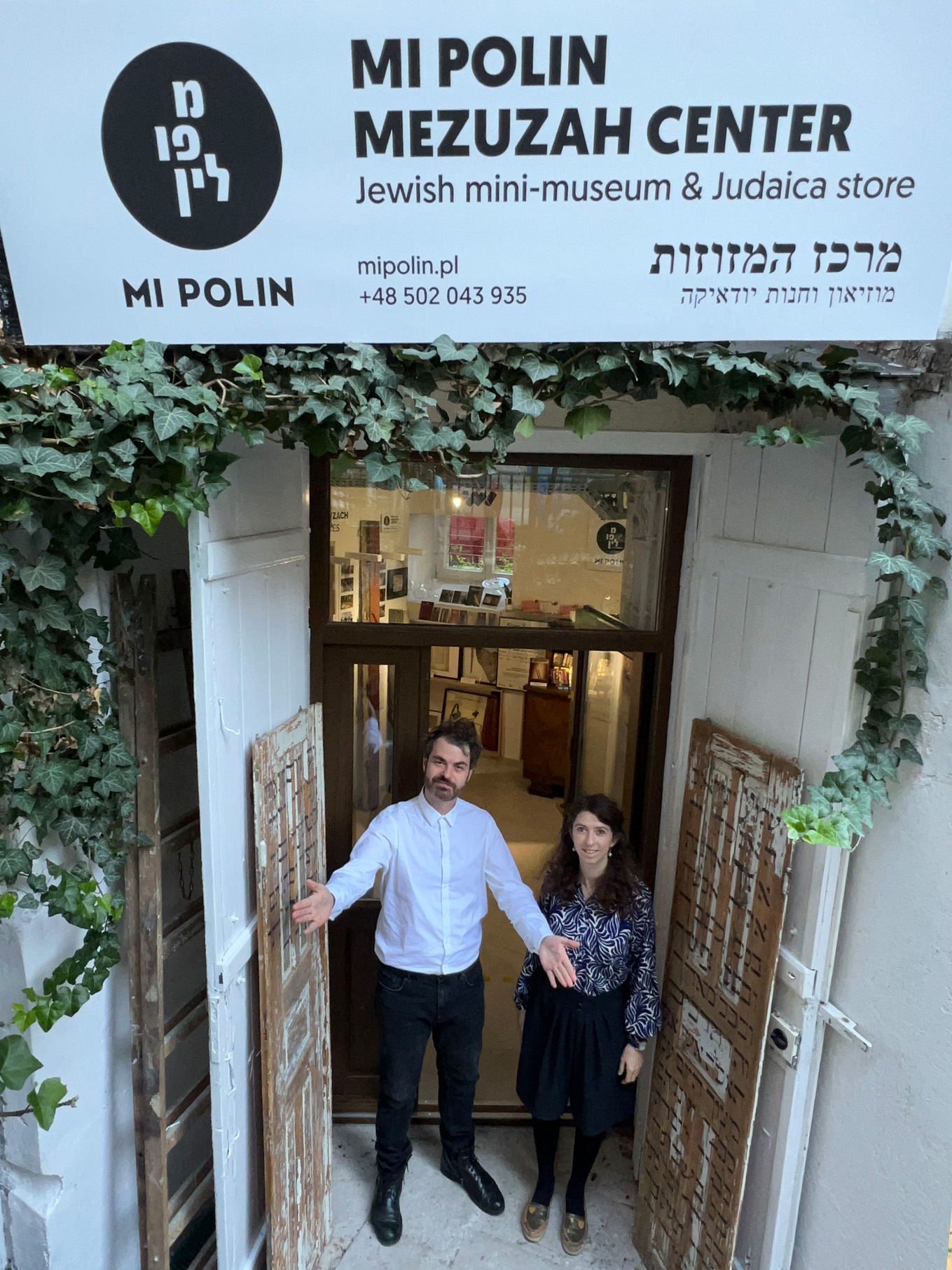 Entrance to the MI POLIN Mezuzah Center with its owners, Helena Czernek and Aleksander Prugar, standing in the doorway