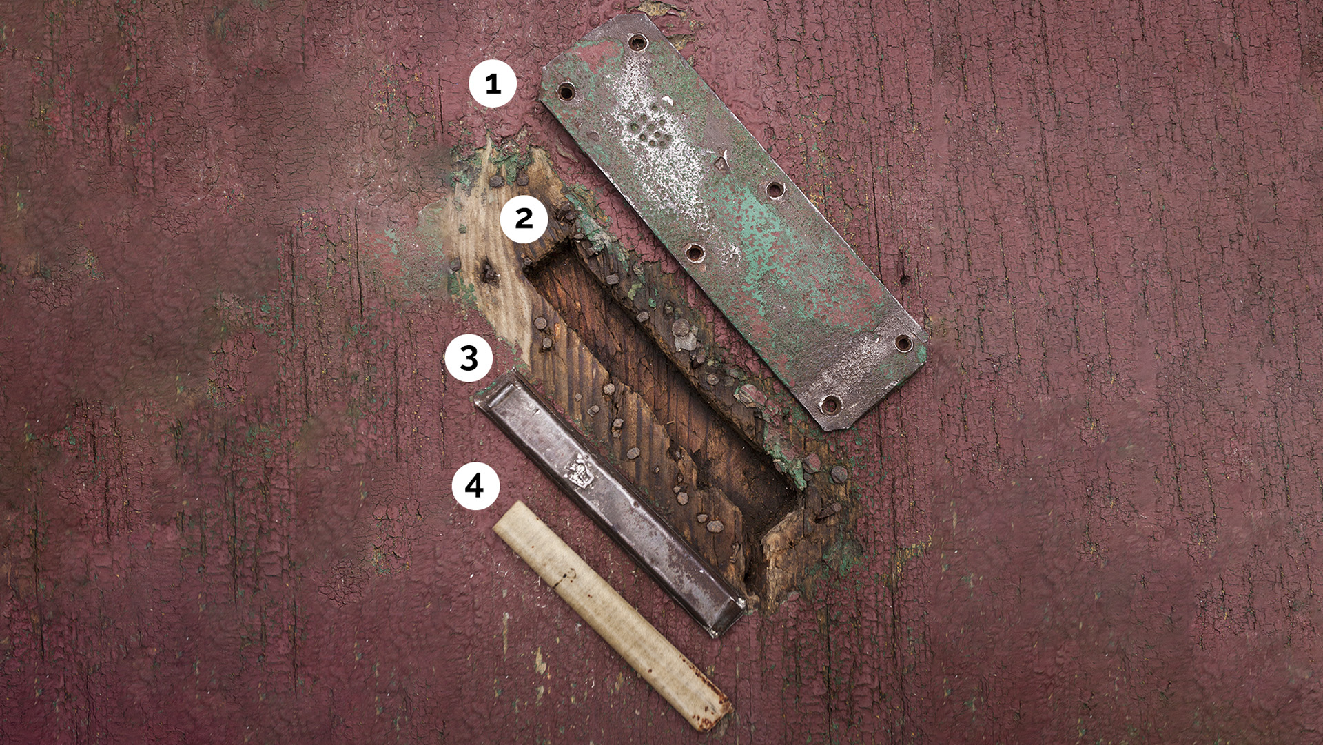 Disassembled pre-war Polish mezuzah showing metal plate with Shin, recessed doorframe, tin container, and parchment scroll—demonstrating mezuzah trace
