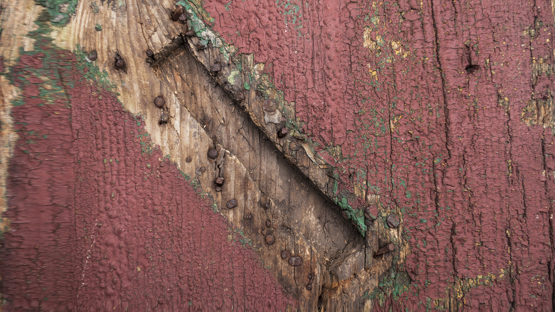 Weathered metal mezuzah plate with letter Shin on a doorframe, showing primitive but secure pre-war mezuzah trace construction