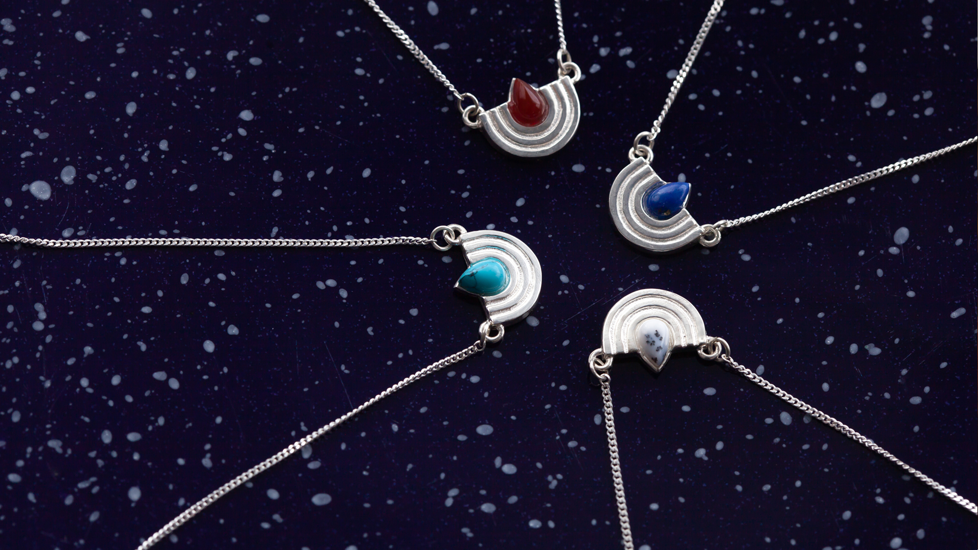 Silver necklaces with menorah-inspired pendants featuring colored stones in red, blue, turquoise, and white, designed by MI POLIN design