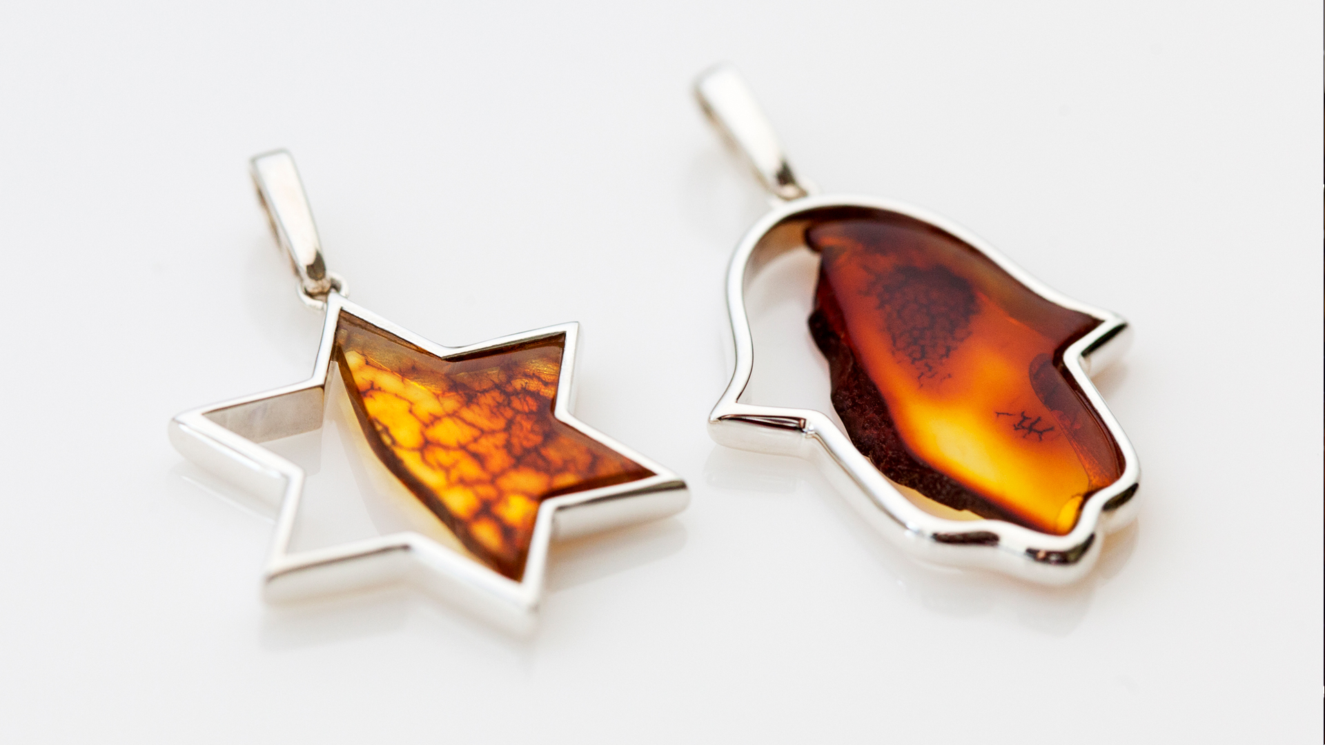 Large silver pendants featuring amber inlays with Jewish motifs, inspired by Israeli deserts and mezuzah trace, designed by MI POLIN design