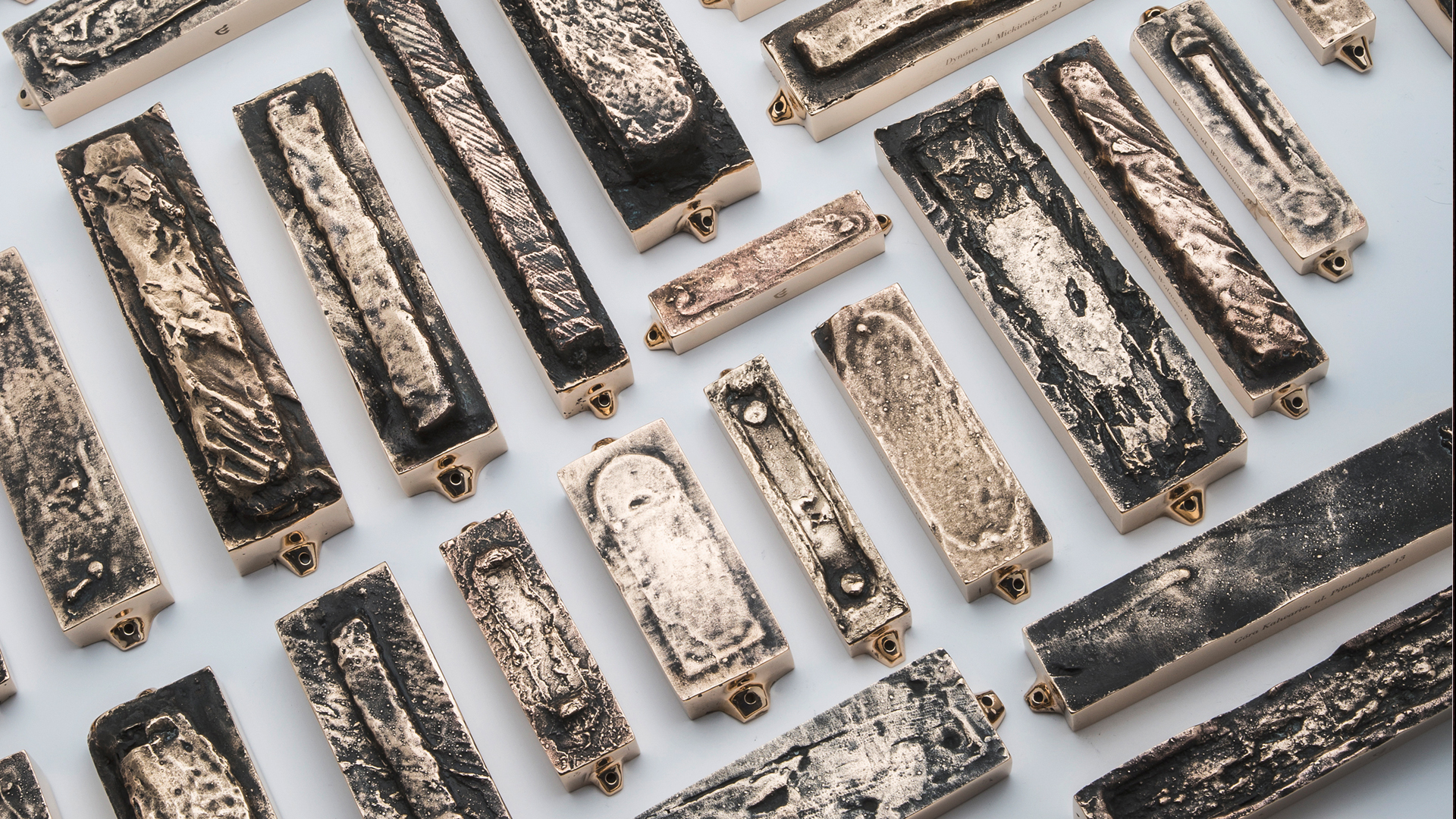 Assorted bronze mezuzah cases cast from original mezuzah traces, each preserving the memory and story of a specific home, designed by MI POLIN design
