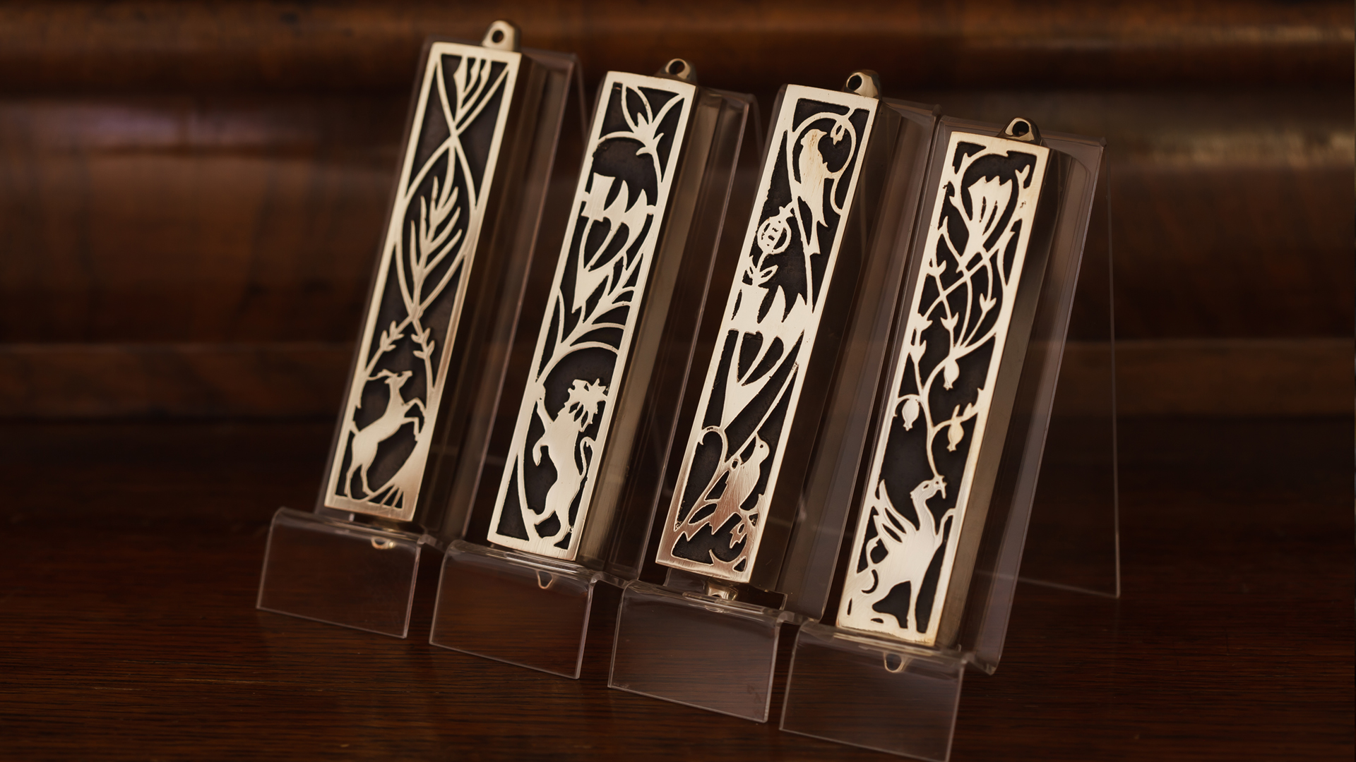 Brass mezuzah cases with intricate cut-out designs of animals significant in Jewish culture, created in collaboration with artist Monika Krajewska and inspired by mezuzah trace, designed by MI POLIN design
