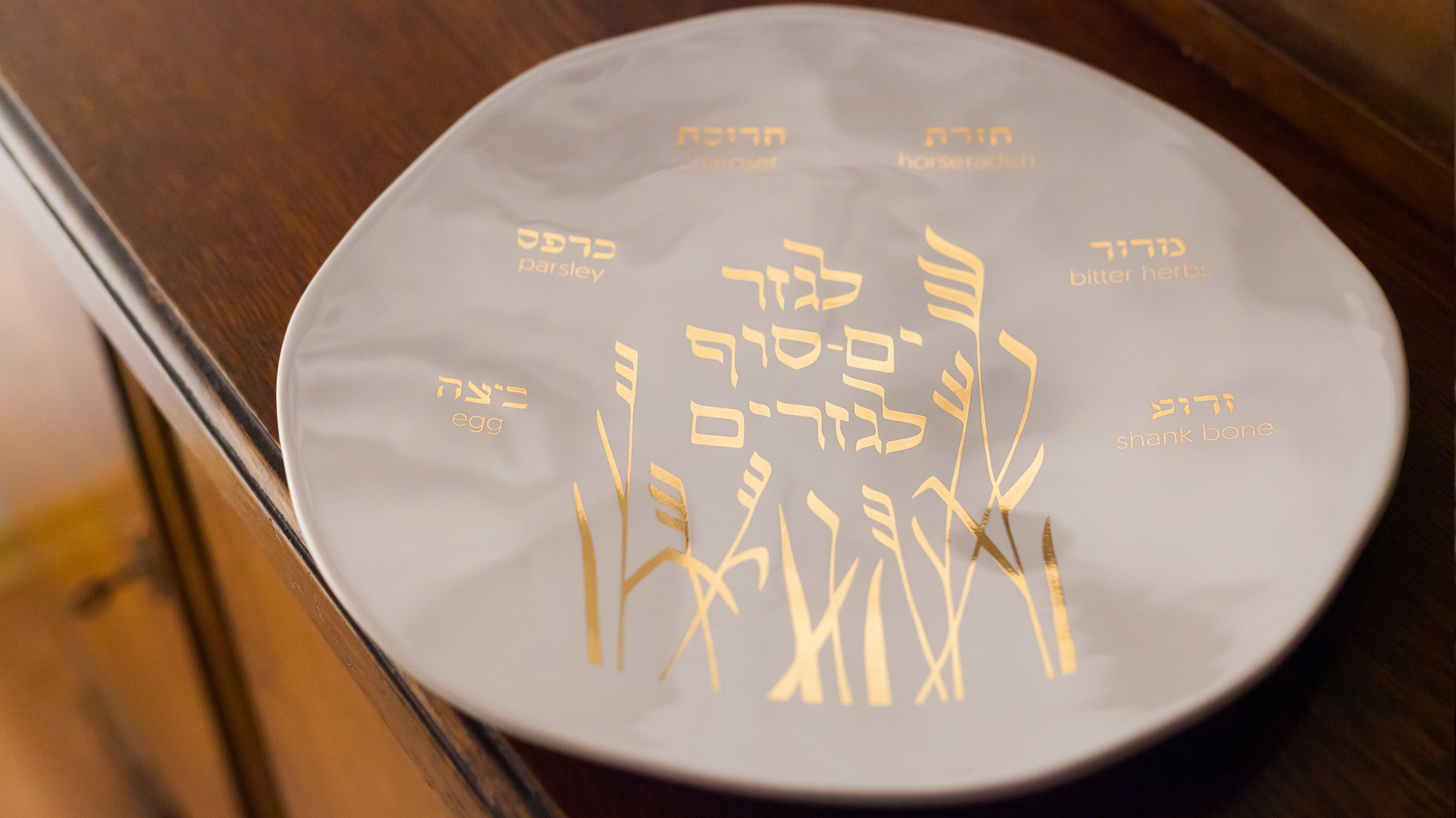 Ceramic Seder plate inspired by Shmura Matzah, featuring an inscription quoting Psalm 136 and motifs of mezuzah trace, designed by MI POLIN design